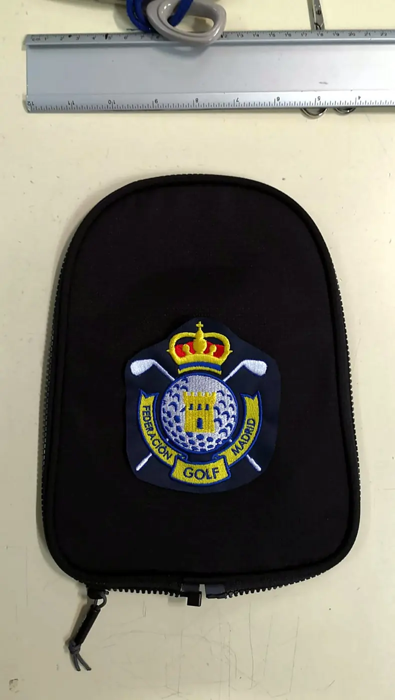 Escudo de club de golf bordado sobre una funda negra